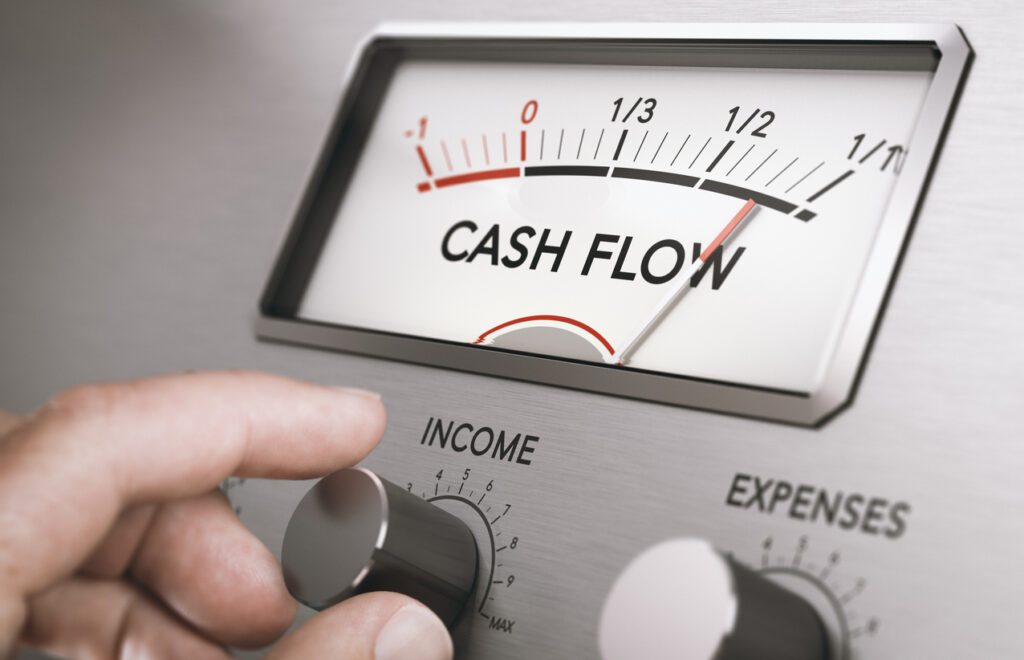 Man turning income knob to increase cash flow amount. Concept of good management of liquidities in a company. Composite image between a hand photography and a 3D background.