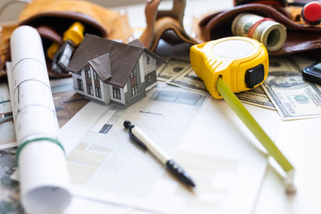 A model house on blueprints with keys to the new home close-up.