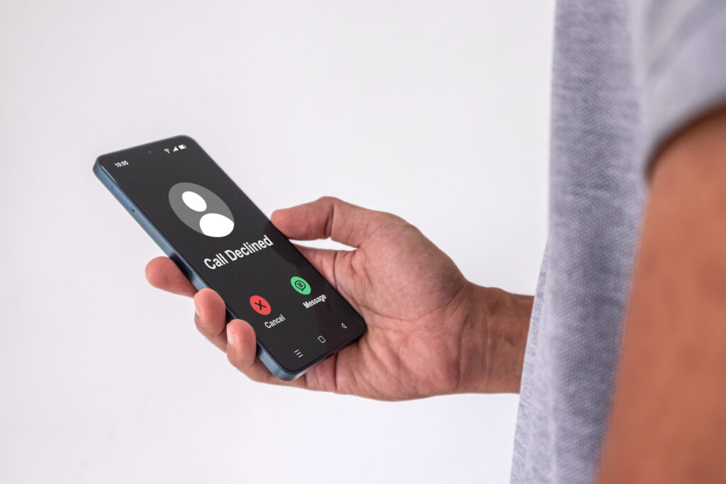 A man holding a mobile phone with Call Declined screen.